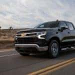 A black 2022 Chevy Silverado LT driving on an open desert road.