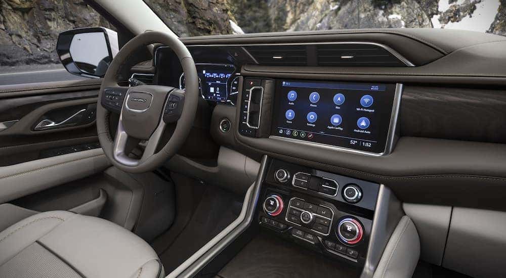 The grey interior of a 2023 GMC Yukon XL Denali with infotainment screen