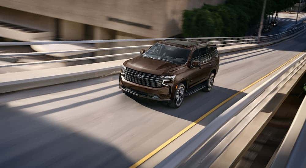 Aerial view of a brown 2022 Chevy Tahoe RST driving on an empty highway