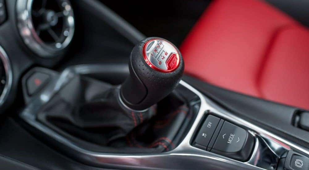 A close up of the red and black manual shift knob in a 2023 Chevy Camaro.