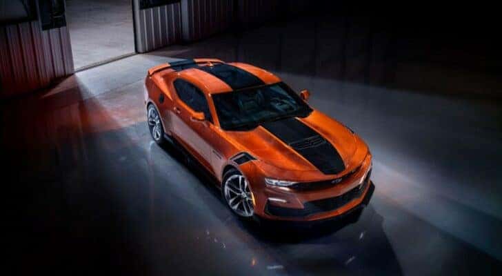 An orange 2023 Chevy Camaro SS is shown in warehouse.