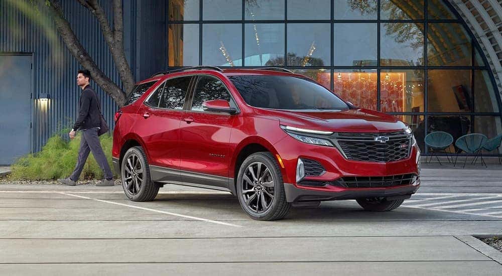 A red 2023 Chevy Equinox RS is shown parked in front of a glass building after leaving a Tullahoma Chevy dealer.