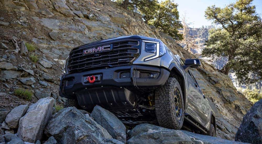 A gray 2023 GMC Sierra AT4x AEV is shown from the front at a low angle.