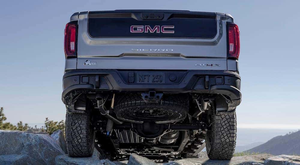 A grey 2024 GMC Sierra AT4x AEV is shown from the rear at a low angle.
