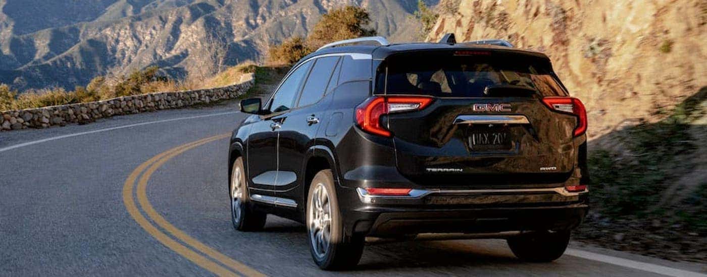 A black 2023 GMC Terrain Denali is shown from the rear at an angle.