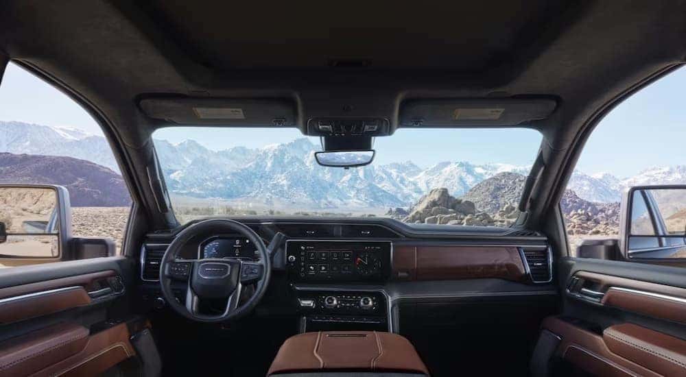 The black and brown interior and dash of a 2020 GMC Sierra HD is shown.