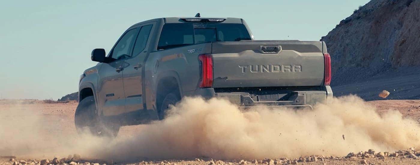 A grey 2022 Toyota Tundra is shown from the rear at an angle while off-road.
