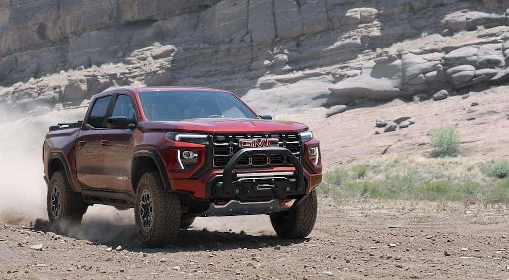 A red 2023 GMC Canyon AT4x is shown from the front at an angle after leaving a used truck dealer.