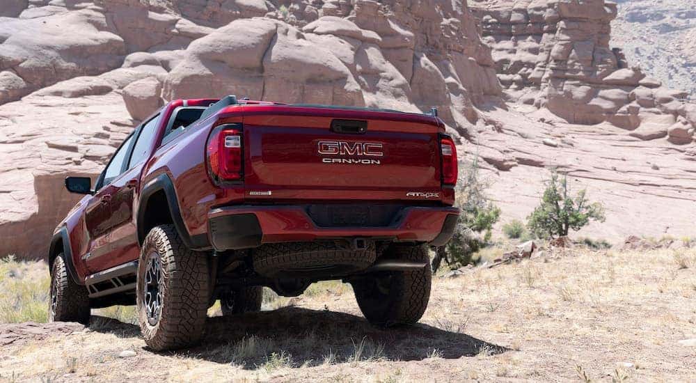 A red 2023 GMC Canyon AT4x is shown from the rear at an angle.