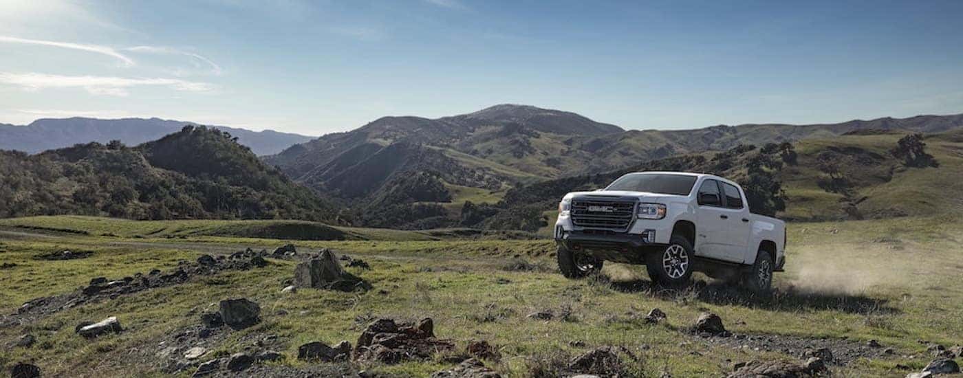 A white 2022 GMC Canyon AT4 is shown from the front at an angle.