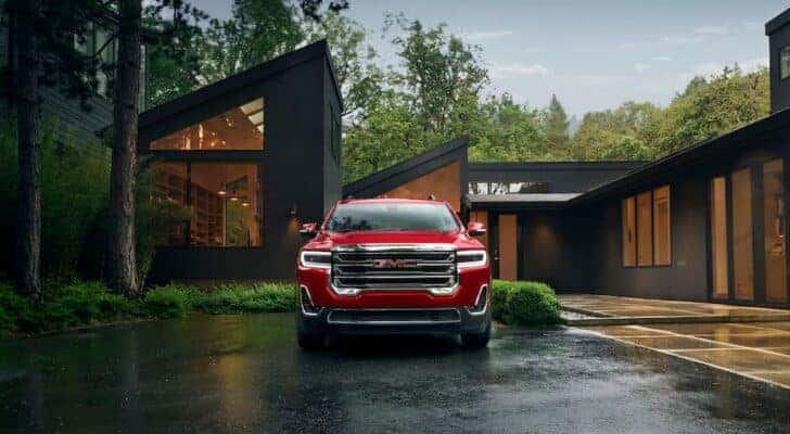 A red 2023 GMC Acadia is shown from the front after leaving a Columbia GMC dealer.