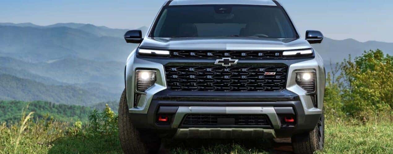 A grey 2024 Chevy Traverse Z71 is shown from the front overlooking a mountain view.