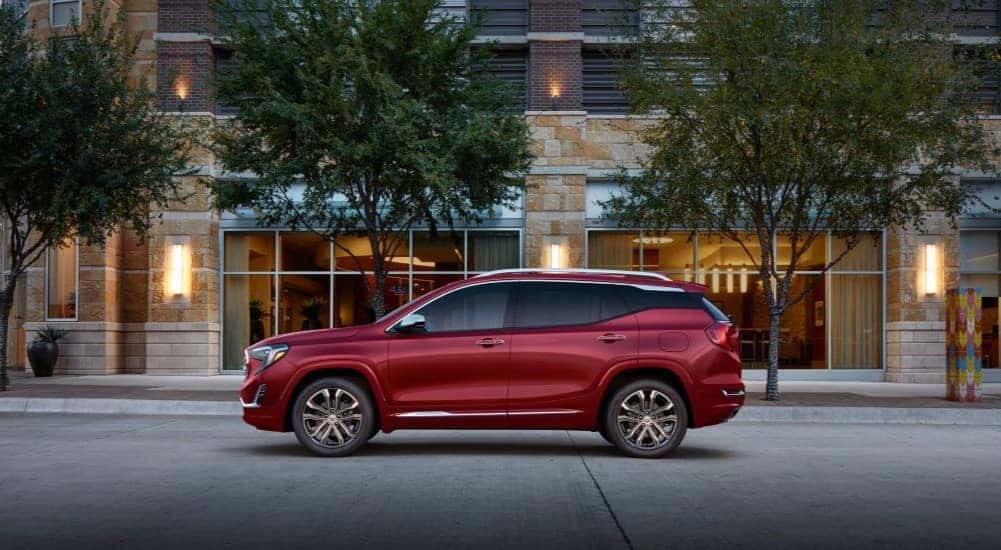 A red 2020 GMC Terrain Denali is shown from the side on a city street.