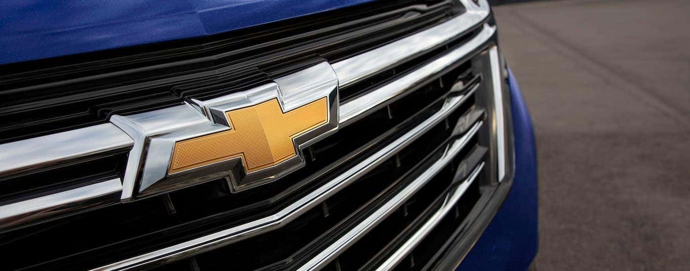 A close-up on the grille of a blue 2023 Chevy Equinox LT is shown.