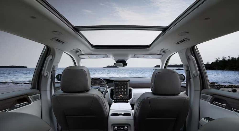 The grey interior of a 2024 GMC Acadia is shown from the rear.