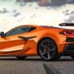An orange 2024 Chevy Corvette Z06 is shown from the rear at an angle.