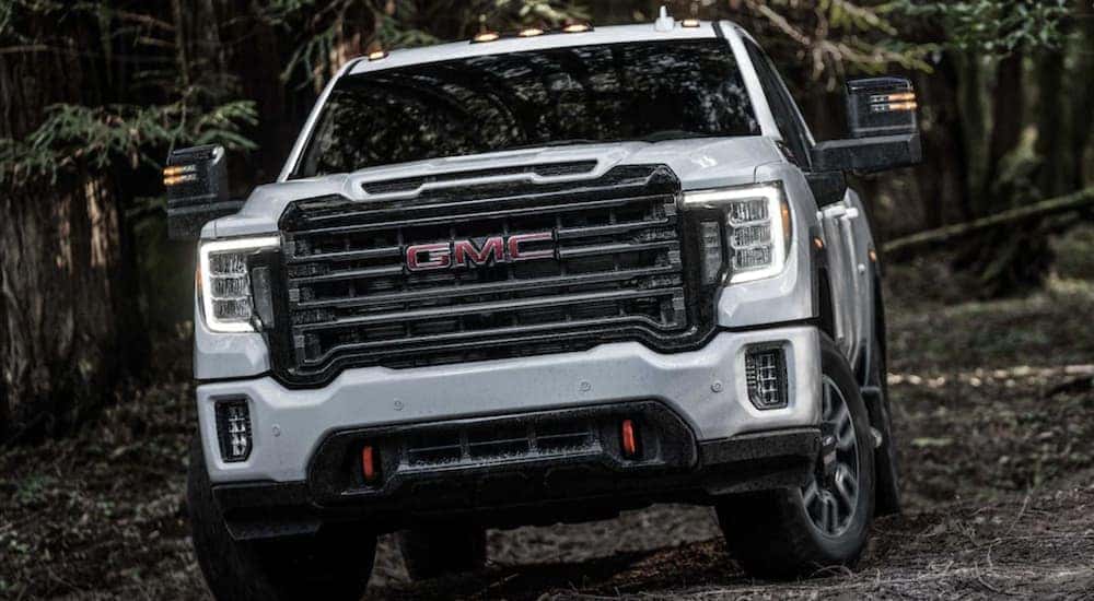 A white 2024 GMC Sierra 2500 HD AT4 is shown driving.