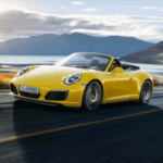 Yellow Porsche 911 convertible driving down highway