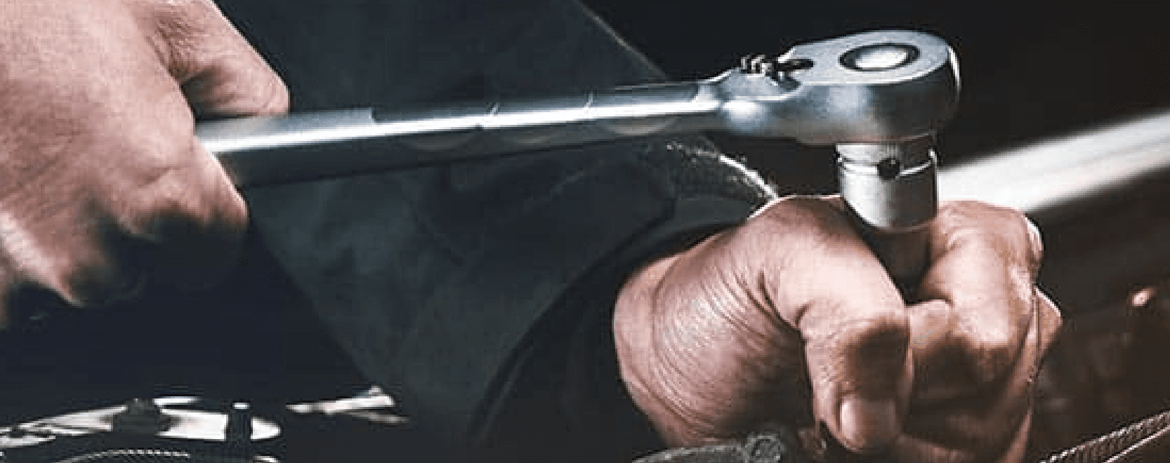 Close up of technician's hands holding socket wrench
