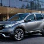 A silver 2020 Honda CR-V Touring is parked outside of a Honda dealer.