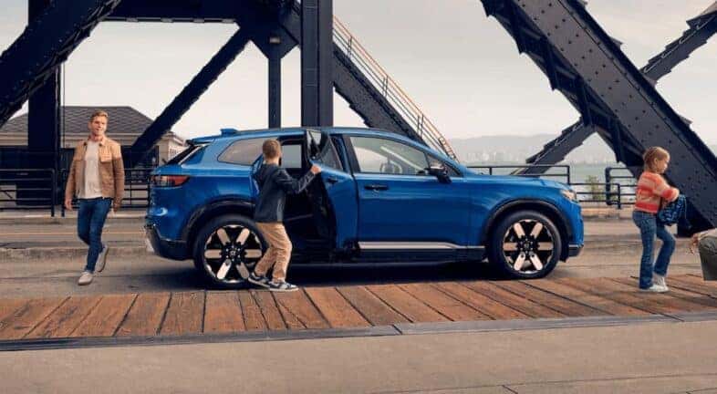 A blue 2024 Honda Prologue Elite is parked on the side of a road after visiting Honda dealers in Rochester.