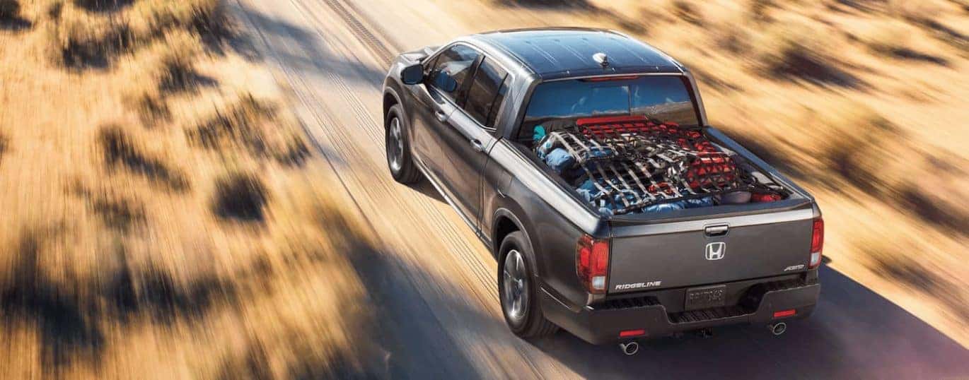 A grey 2022 Honda Ridgeline is shown driving during a 2022 Honda Ridgeline vs 2022 Chevy Colorado comparison.
