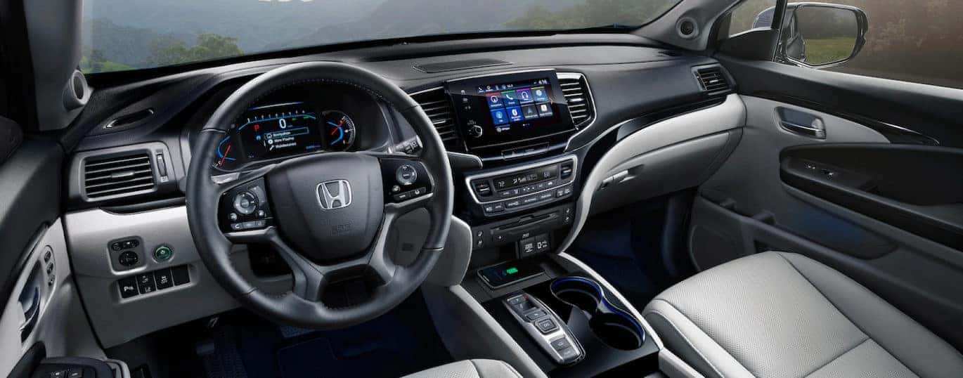 The black and grey interior of a 2022 Honda Pilot Elite is shown during a 2022 Honda Pilot vs 2022 Kia Telluride comparison.