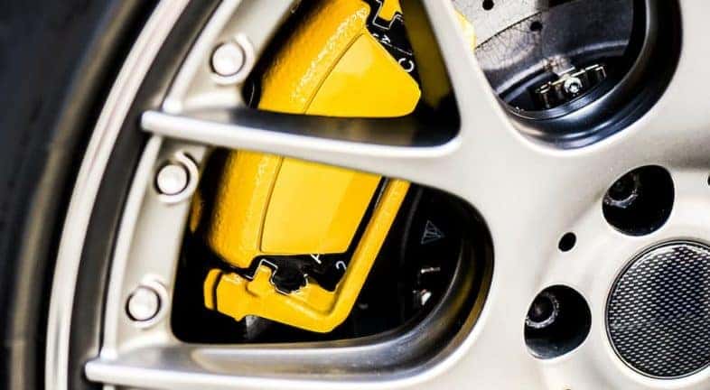 A yellow brake caliper is shown in close-up.