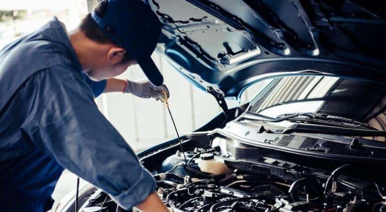 A mechanic is shown performing an oil change near Ironequoit.