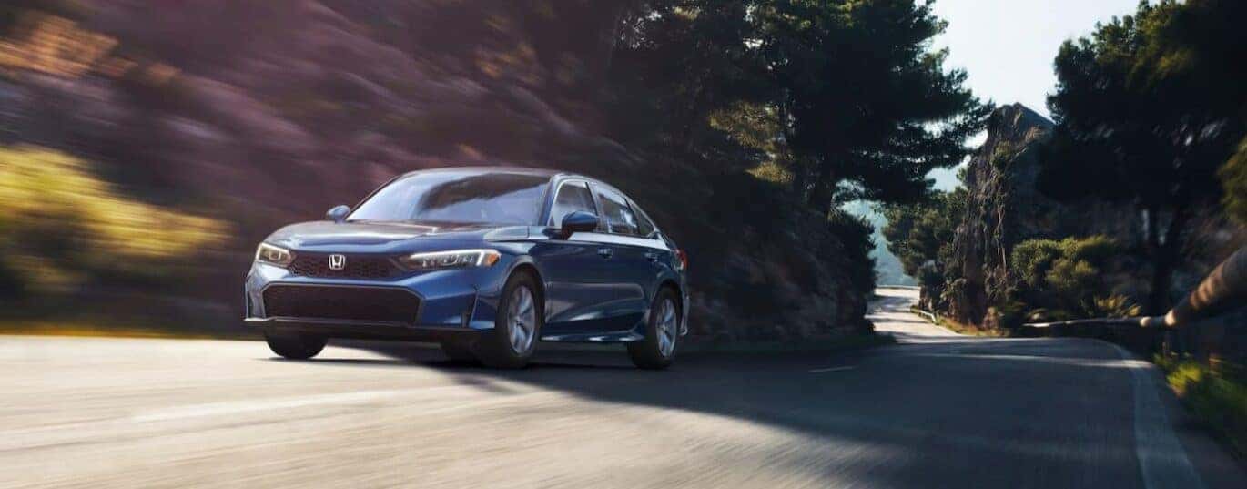 A blue 2025 Honda Civic LX is shown driving on a street.