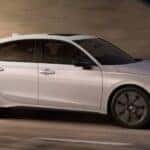 A white 2025 Honda Civic Hatchback is shown driving in a tunnel.