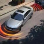 Simulated parking sensor lines emanating from a silver 2025 Honda Accord Hybrid while parallel parking.