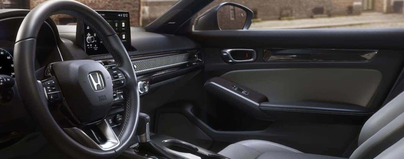 The black interior and dash are shown in a 2025 Honda Civic Hybrid.