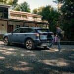 A blue 2025 Honda Prologue parked near a family house.