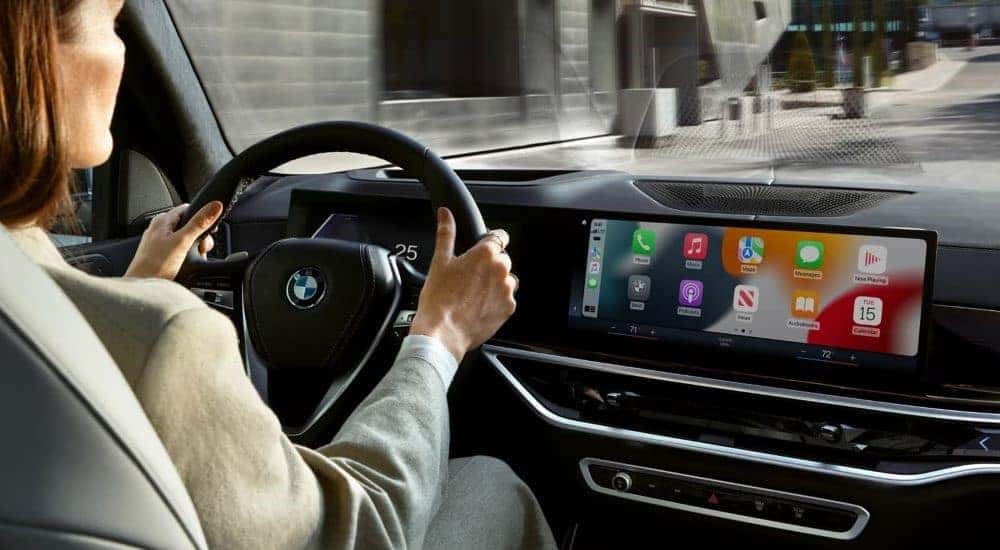 A person is shown driving a 2024 BMW X5.