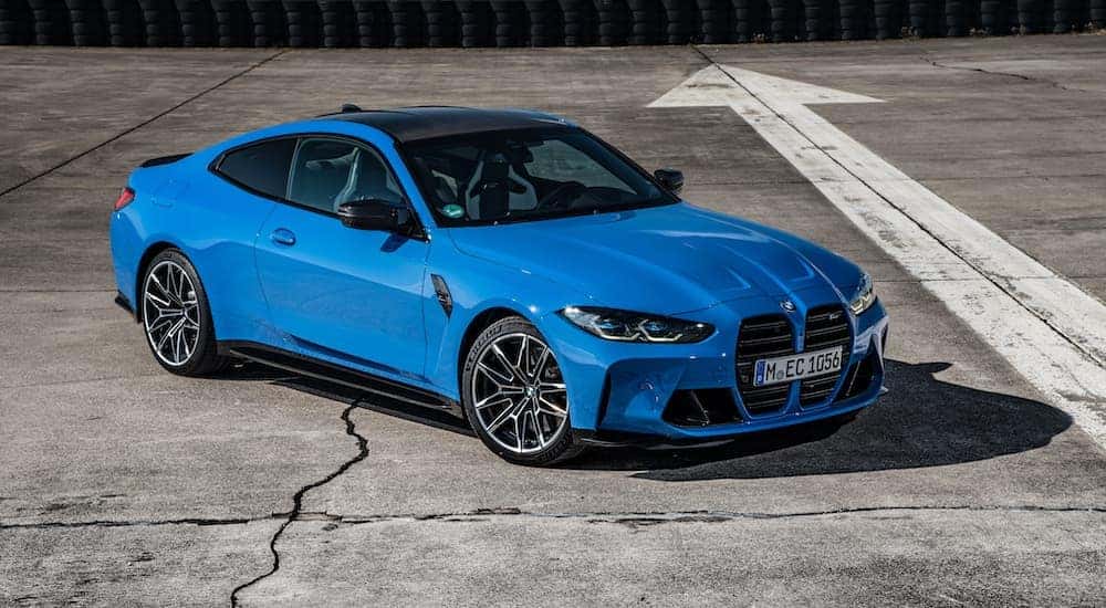 A blue 2024 BMW M4 is shown from the front at an angle after leaving a BMW dealer near me.