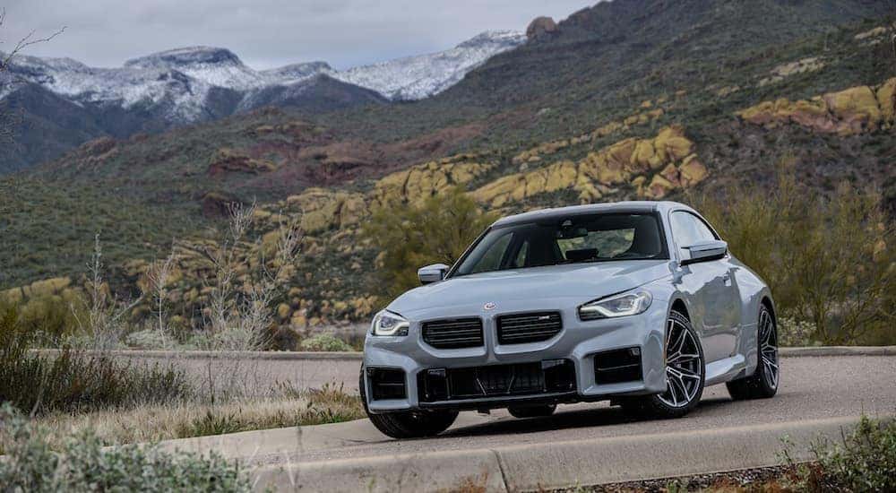 A gray 2022 BMW M2 is shown from the front at an angle.
