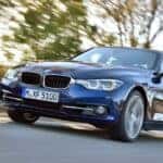A blue 2015 BMW 3 series is shown from the front at an angle after leaving a BMW service center.