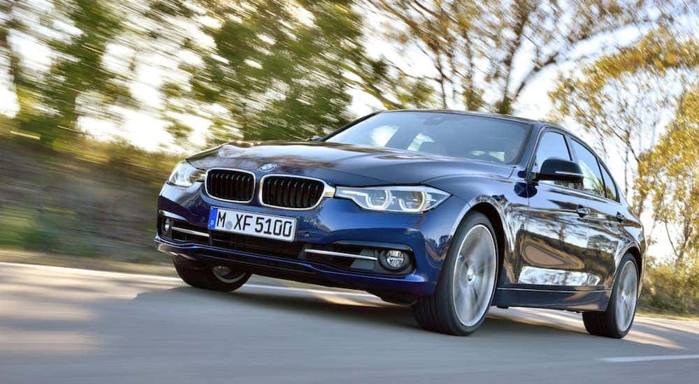 A blue 2015 BMW 3 series is shown from the front at an angle after leaving a BMW service center.