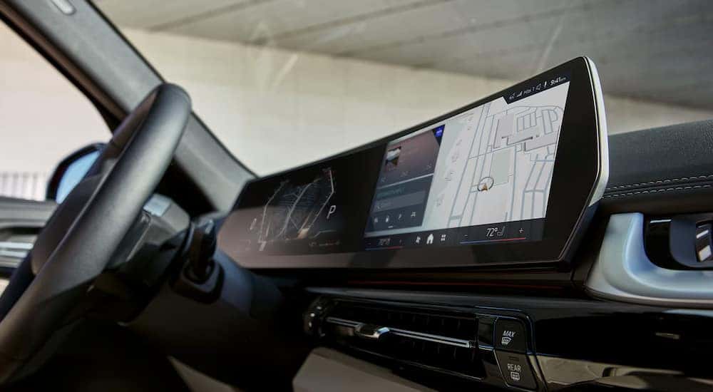 The steering wheel and infotainment screen in a used BMW for sale, a 2023 BMW X1.