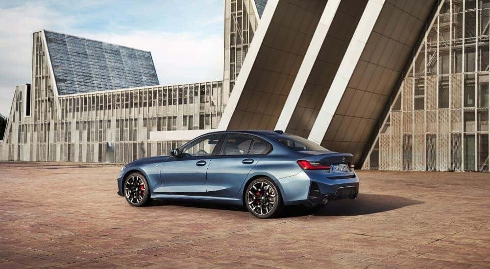 A blue 2025 BMW 3 Series is shown from the side.