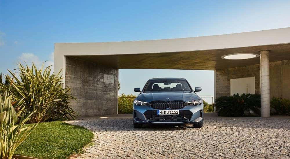 A blue 2025 BMW 3 Series is shown from the front.