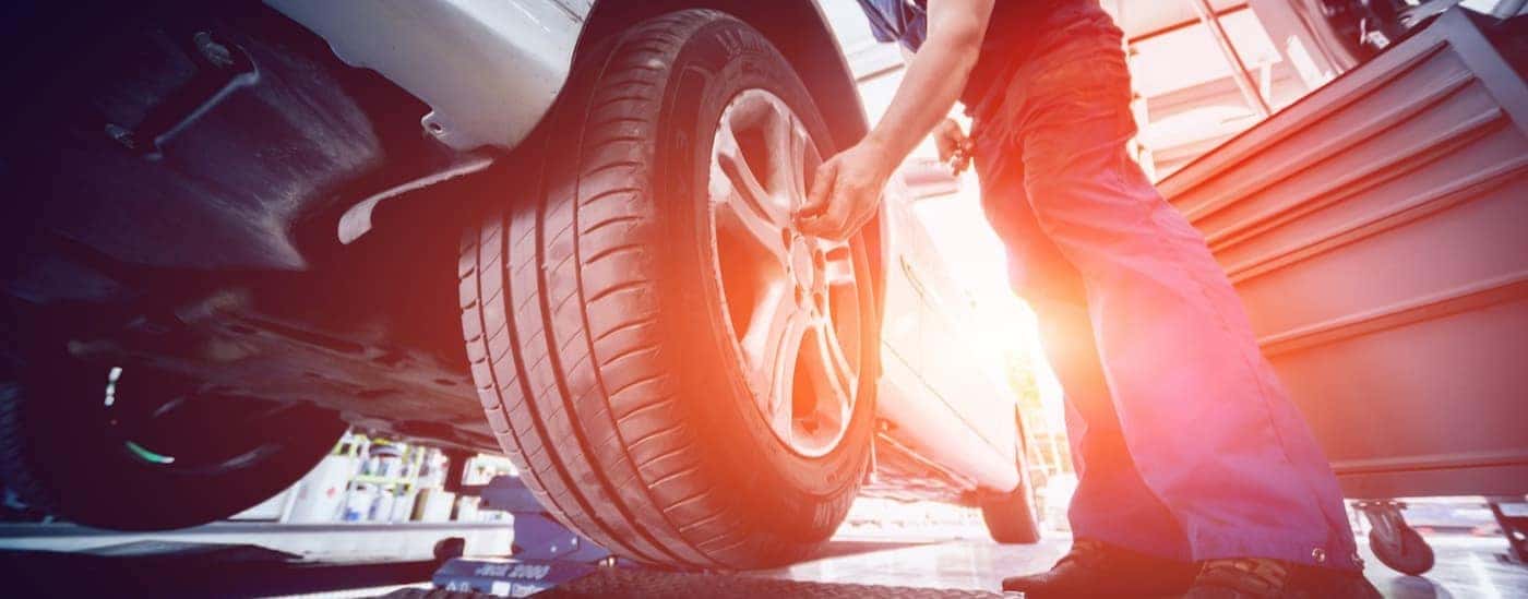 A technician is shown tightening the lug nut on a tire.
