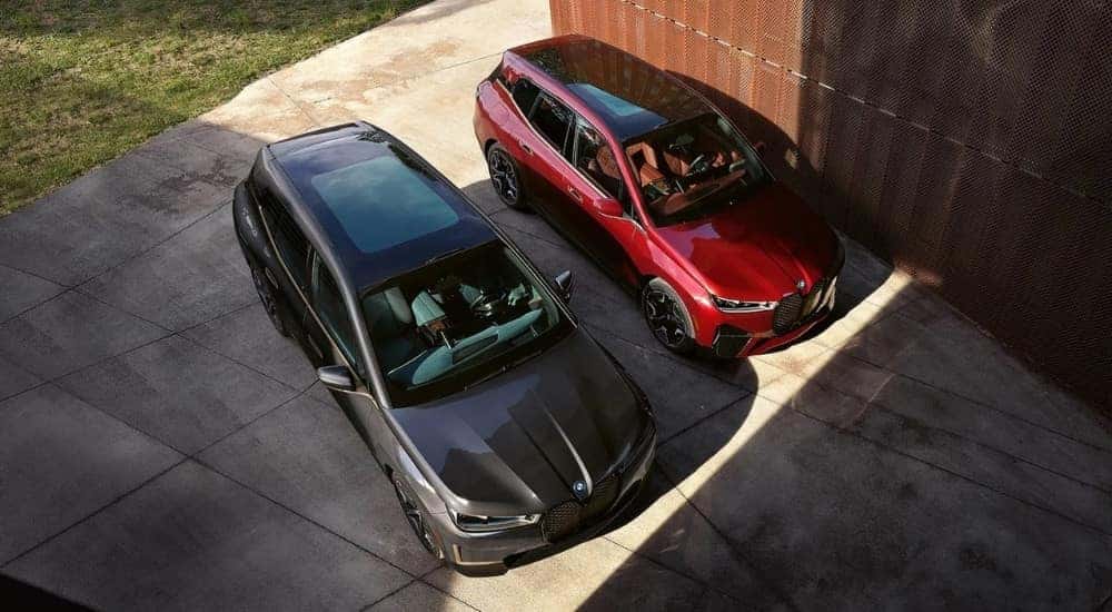 A grey and a red 2023 BMW iX are shown from a high angle.