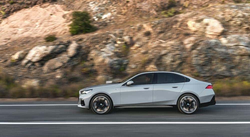 A gray 2024 BMW i5 is shown from the side.
