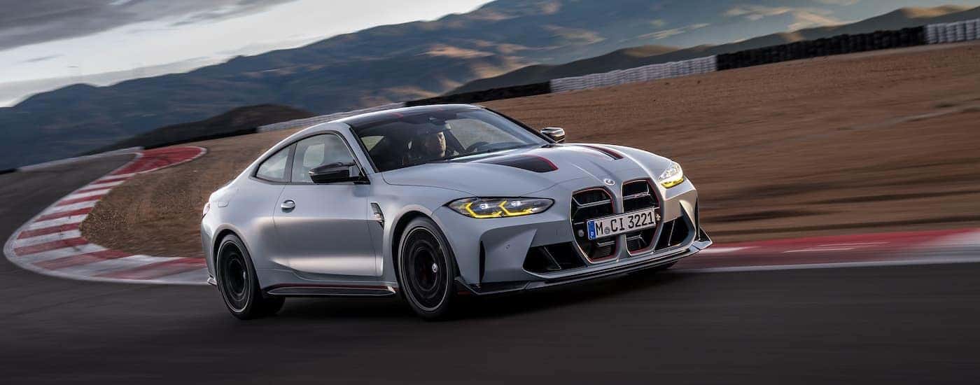 A grey 2024 BMW M4 CSL is shown from the front at an angle.
