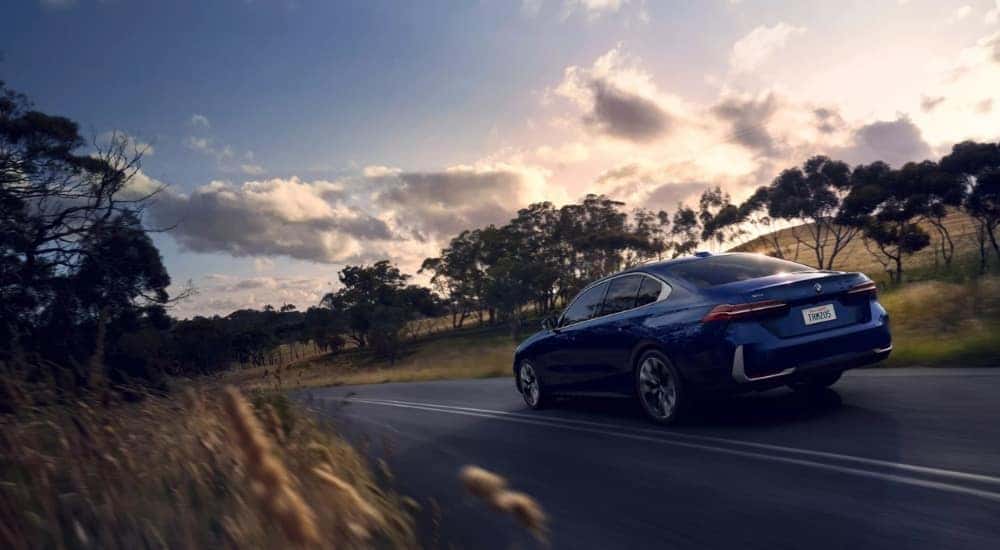 A blue 2025 530i Xdrive is shown from the rear at an angle.