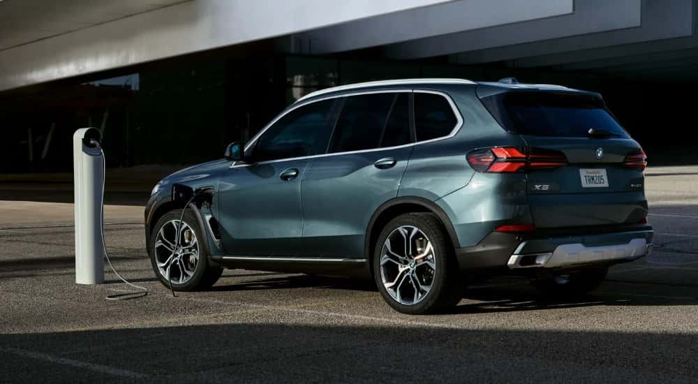 A green 2026 BMW X5 charging.