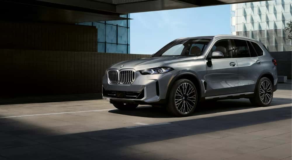 A silver 2026 BMW X5 for sale near Plano on a parking space.