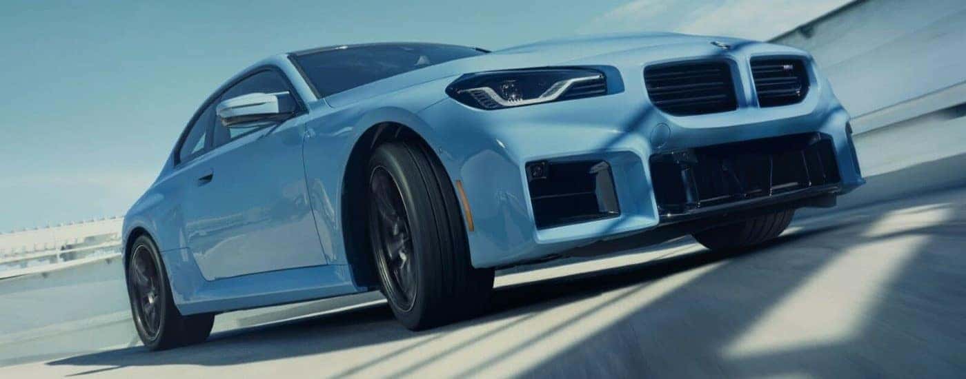 A blue 2024 BMW M2 is shown leaving a BMW dealer in McKinney.